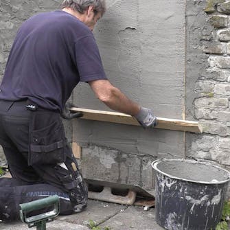 Mur med ødelagt puss og løse fuger: Rett opp med et langt bord Mur med ødelagt puss og løse fuger: Rett opp med et langt bord